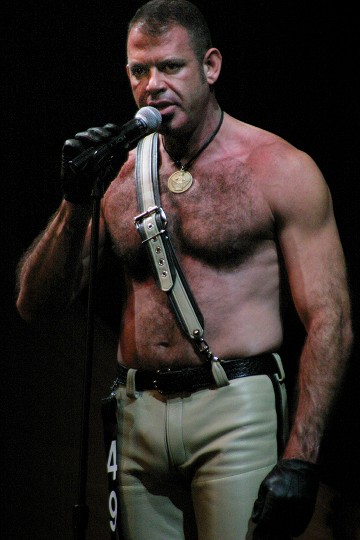Colour photo of Michael giving his speech at the International Mr Leather Contest, taken May 2005