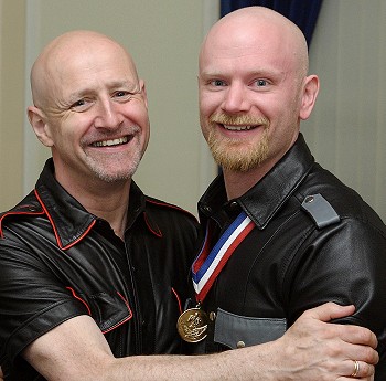 Dave and I wearing leather shirts, hugging each other and smiling at the camera
