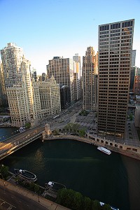 View of downtown skyscrapers looming over a bright green river