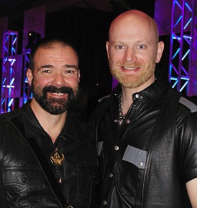 Mid-shot of John and Jason Henrix, standing next to each other wearing black leather shirts