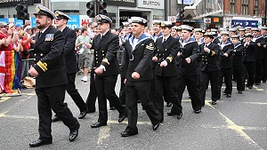 A troop of uniformed personnel marching in unison down Oxford Street in central London