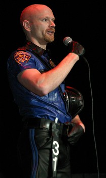 Colour photo of John giving his speech at the International Mr Leather Contest, taken May 2003
