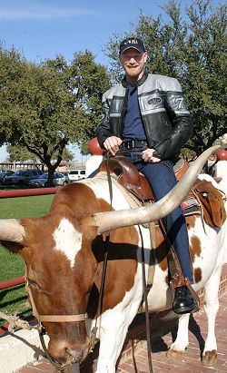 John sitting on a Longhorn Bull in Fort Worth, Texas