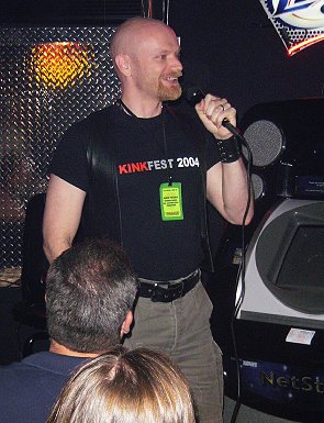 John talking into a microphone in a crowded bar