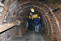Groups of leathermen in yellow hard hats waiting to go down the coal mine