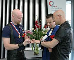 Photo of Dave and John exchanging rings during their partnership registration ceremomy. June 2003